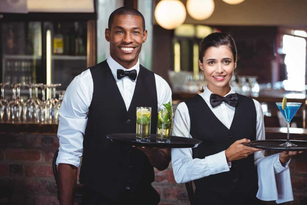 Waiter and waitress holding a serving tray