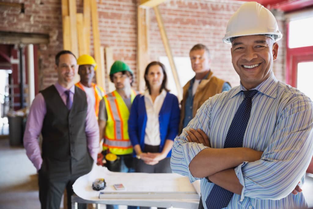 Portrait of architect with team standing at construction site